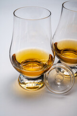 Tulip-shaped tasting glasses with dram of Scotch single malt or blended whisky on white background