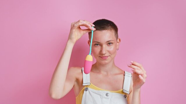 Woman holding Kegel trainer and looking with open mouth at the camer