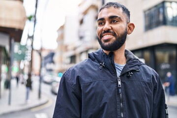 Naklejka premium Young hispanic man smiling confident looking to the side at street