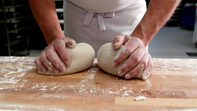 B&auml;cker formt mit der Hand Teiglinge um danach Brot zu backen