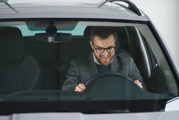 His true love. Portrait of a mature man smiling happily sitting in a brand new car