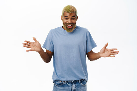 Handsome Happy Guy Looks Down With Surprised Face, Found Smth Amazing, Stands Over White Background