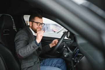 Handsome businessman driving car before buying