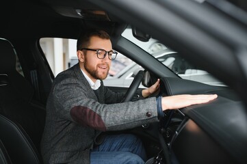 Handsome businessman driving car before buying