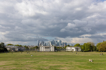 Canary Wharf view from Greenwich Park, filled with people enjoying leisure activity on a cloudy...