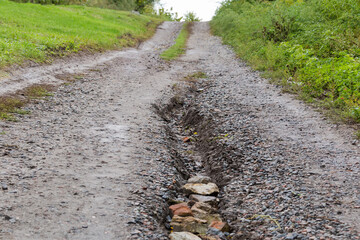 Washed out dirt road on hillside with scour after rain
