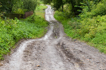 Wet dirt road on the hillside with washouts after rain