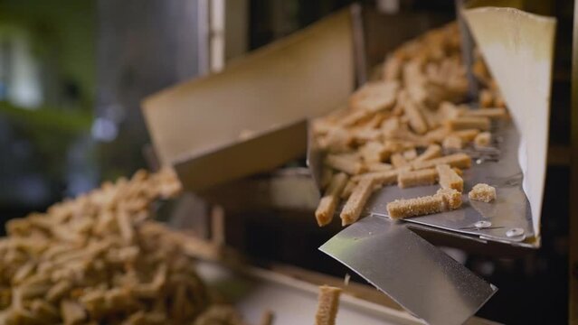 Bread in thin slices in a bakery, shop, supermarket or factory. Automatic slicing of bread for further packaging. Breadcrumbs production technology. Factory for the production of crackers.