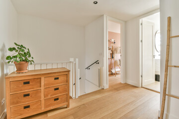 a room with wood floors and white walls, including a wooden dresser in the fore - image taken from...