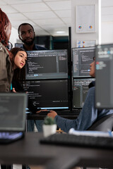 Multi ethnic engineers analyzing server code and database, brainstorming program ideas to develop...
