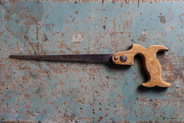 Vintage keyhole saw on a rustic surface flat lay view