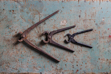 Three vintage pincers on a rustic surface flat lay