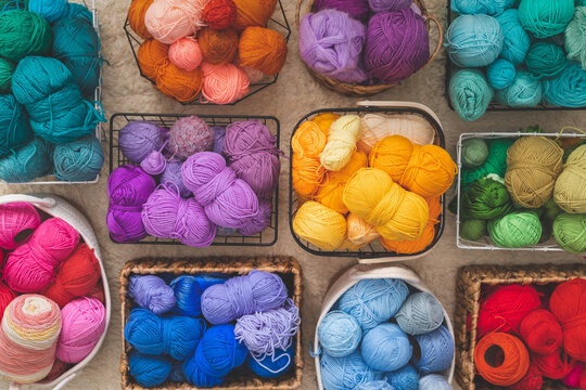 Many baskets made of natural eco-friendly materials. Multicolor yarn for knitting, knitting needles and scissors. Home storage concept and hobby handmade.