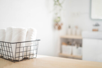 Fototapeta na wymiar Spa white towel rolled in metallic basket comfortable hygiene fresh textile bathroom. Blurred background