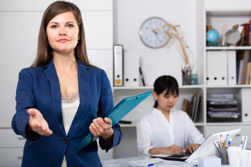 Elegant female assistant politely welcoming to modern company office