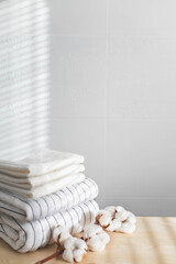 Fototapeta na wymiar Bath fresh towels pile soft textile cotton body care neatly folded white gray laundry flower shelf