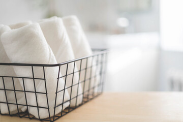 Fototapeta na wymiar Spa white towel rolled in metallic basket comfortable hygiene fresh textile bathroom. Blurred background