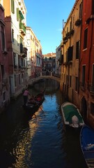 View of the Venetian Canal on a sunny day, buildings and boats. Venice, Italy