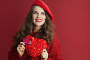 pensive stylish female in red sweater and beret with red heart