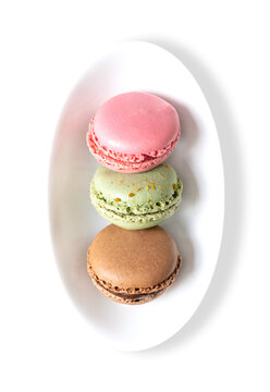 Macarons, French macaroons in a white bowl. Sweet meringue-based confection, Parisian-style, made with egg white, sugar, almonds and food coloring, presented with ganache, buttercream or jam filling.