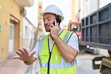 Middle age man architect talking on smartphone at street