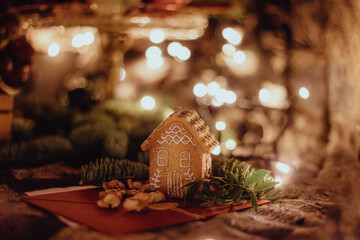 Gingerbread house ornament with twinkle lights, fir and nuts, christmas, holiday time, dark academia, dark and moody