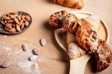 Closeup of almonds in wooden spoon with bread on wooden background, vintage tones, breadbread
