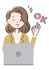 パソコン操作でOKサインを出すスーツ姿の若い女性
