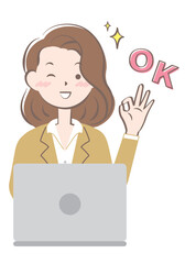 パソコン操作でOKサインを出すスーツ姿の若い女性