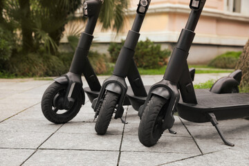 Row of electric scooters outdoors, closeup. Rental service