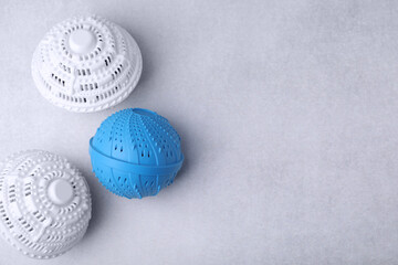 Laundry dryer balls on light grey table, flat lay. Space for text