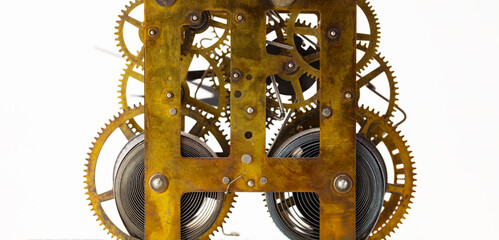 Gears in motion. Old brass gears of a clock mechanism, on white background. 