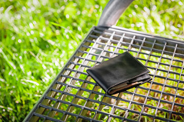Black wallet on metal bench outdoors, space for text. Lost and found