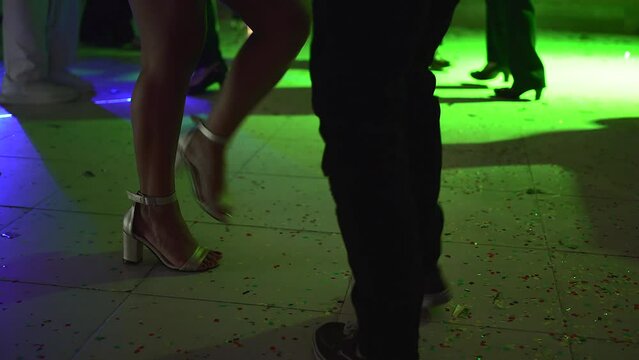 couple dancing salsa at a party with lights of different colors