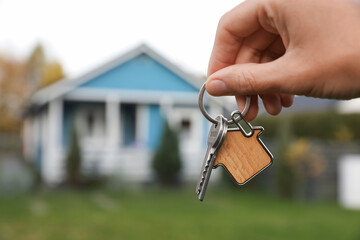 Woman holding house keys outdoors, closeup with space for text. Real estate agent - obrazy, fototapety, plakaty