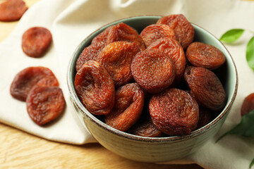 Bowl of tasty apricots on wooden table, closeup. Dried fruits