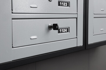 Closed metal mailboxes with keyholes and sequence numbers indoors