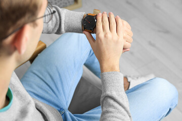 Man checking time in room, closeup. Being late