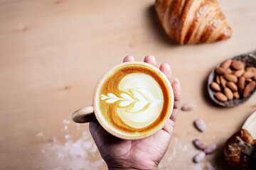 Hot coffee and croissants on vintage wooden background. Breakfast with coffee and fresh pastries.