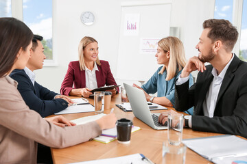 Businesswoman having meeting with her employees in office