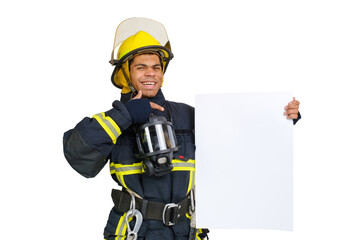 Young smiling African American fireman wearing uniform and helmet looking to the camera and holding blank paper sheet in hand and finger pointing. Copy space for text, isolated on white background 