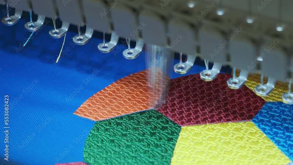 Aufkleber an automated machine embroiders a multi-color geometric pattern on fabric