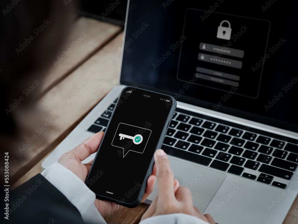 Poster two-factor authentication (2fa) concept. key icon on smart phone screen in hand near laptop computer