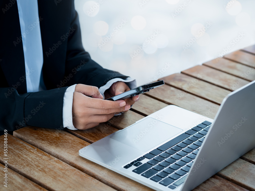 Poster black smart mobile phone in business woman's hand in suit who holding and using near the notebook co