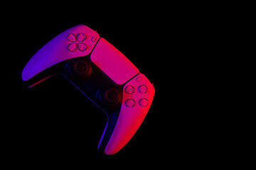Modern white gamepad illuminated red and blue on a black background, copy space, game controller for video games. © sav_an_dreas