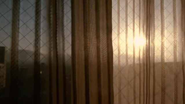 Morning sun lighting through the transparent curtain on the window.
