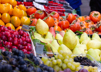 Fruit variety on street food market in Istanbul. Pears, grapes, cherries, kakis and tangerines on stall