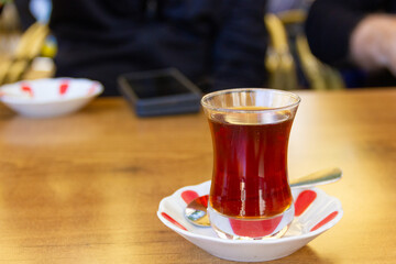 Turkish tea on table served in the traditional way. Tulip-shaped glass called ince belli in...