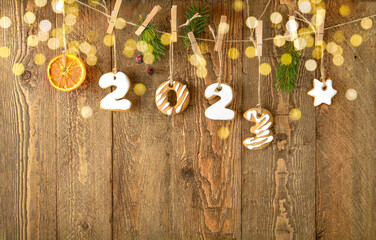Gingerbread cookies in form numbers 2023 on rustic wooden background with defocus lights. Copy space