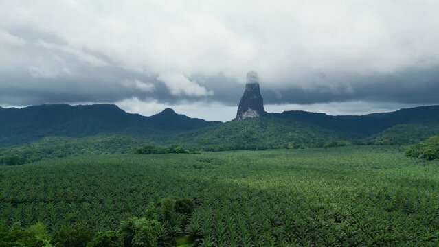 Aerial view of the Pico Cao Grande mountain, in rainy Sao Tome - rising, drone shot